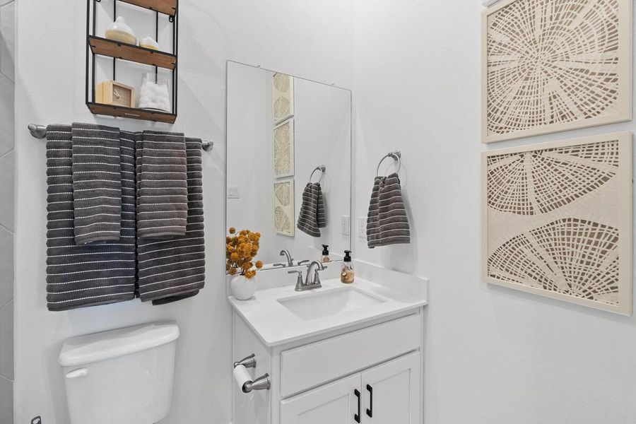 Half bathroom with vanity and toilet