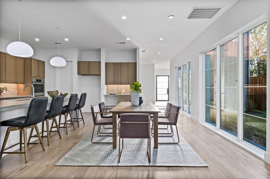 Dining area featuring light hardwood / wood-style flooring, a healthy amount of sunlight, and sink