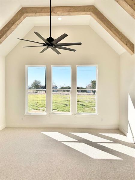 Additional living space featuring a ceiling fan, carpet, lofted ceiling with beams, and baseboards