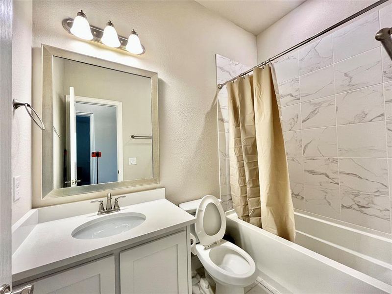 Full bathroom with toilet, shower / tub combo with curtain, and vanity