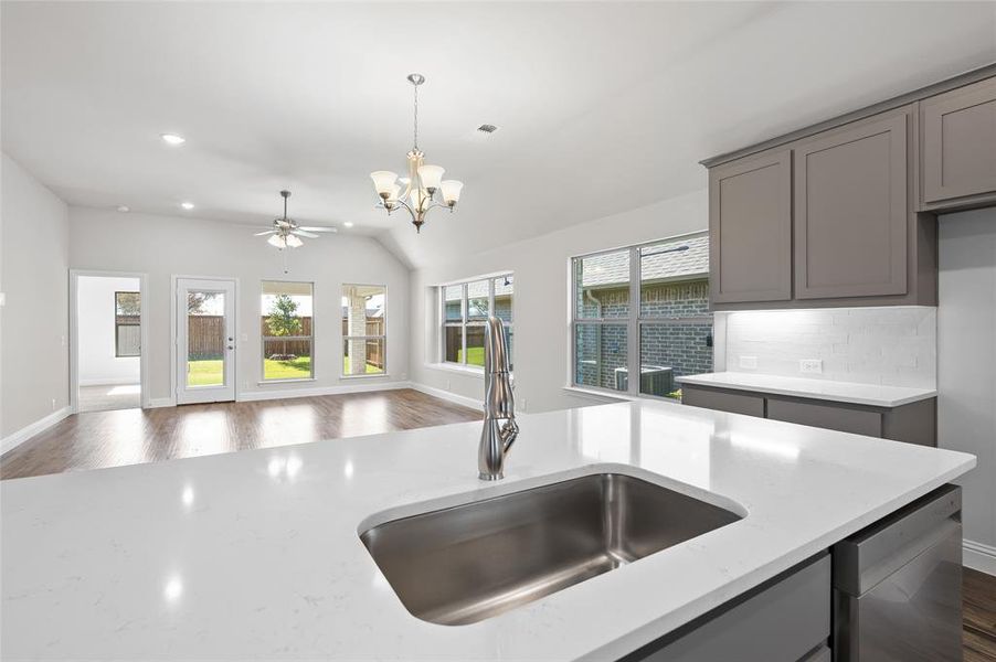 Kitchen with gray cabinets, dark wood-type flooring, plenty of natural light, recessed lighting, and lofted ceiling
