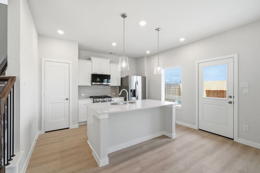 A kitchen with white cabinets.