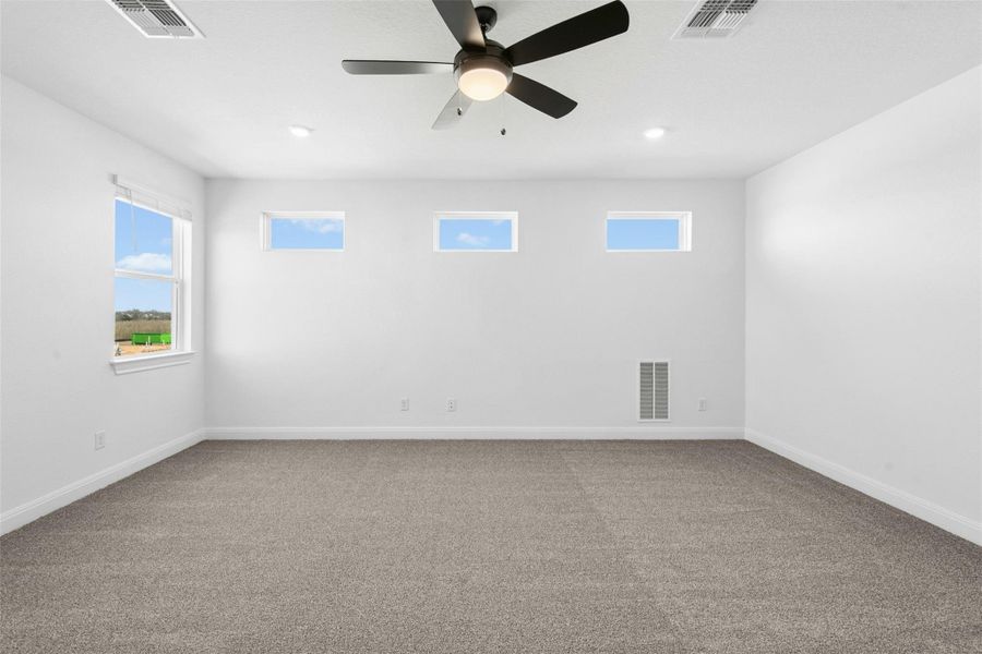 Unfurnished room featuring light carpet and ceiling fan