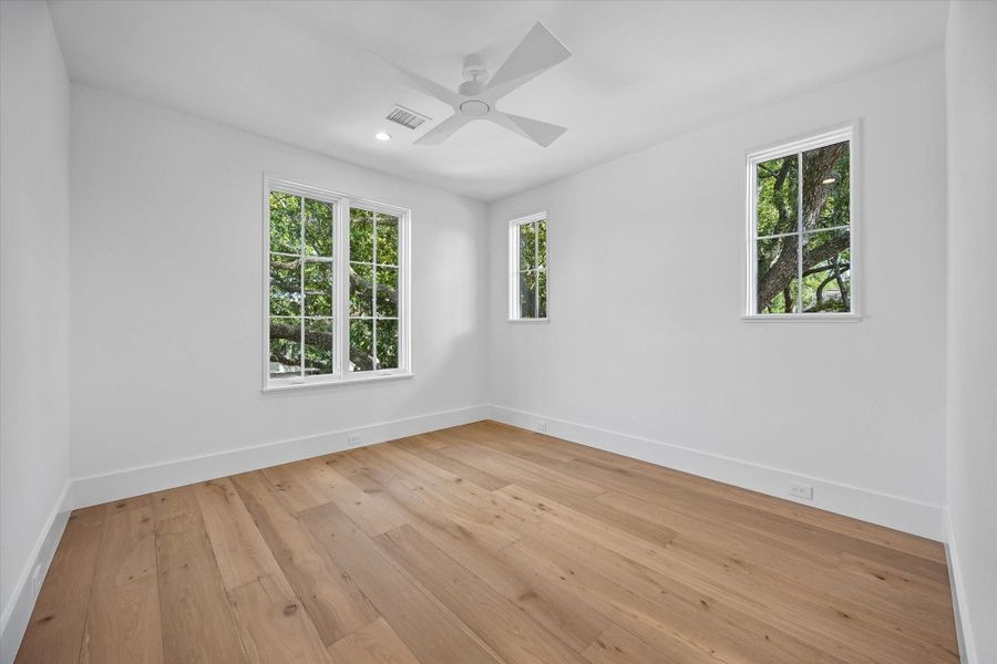 Bedroom Three with tree-top views White Oak Hardwwods and ceiling fan Bedroom Three with tree-top views White Oak Hardwwods and ceiling fan