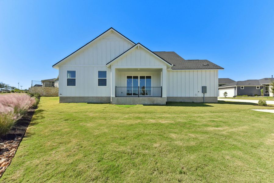 Rear view of house with board and batten siding and a lawn
