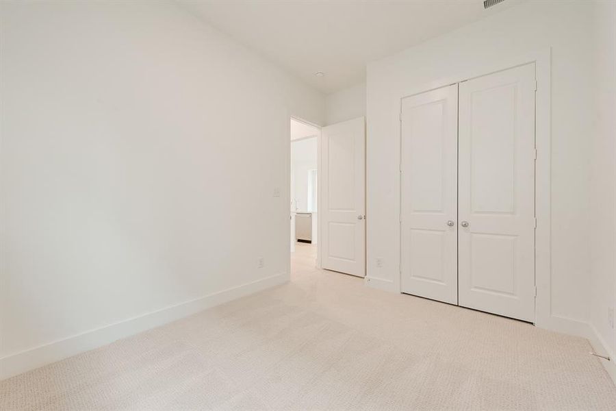 Unfurnished bedroom featuring light colored carpet and a closet Unfurnished bedroom featuring light colored carpet and a closet
