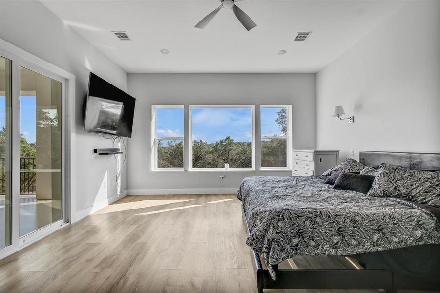 Bedroom with luxury vinyl finished floors, access to outside, and a ceiling fan