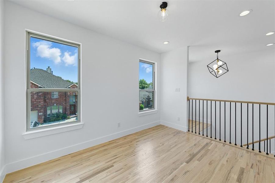 Spare room featuring light wood finished floors, recessed lighting, and a chandelier