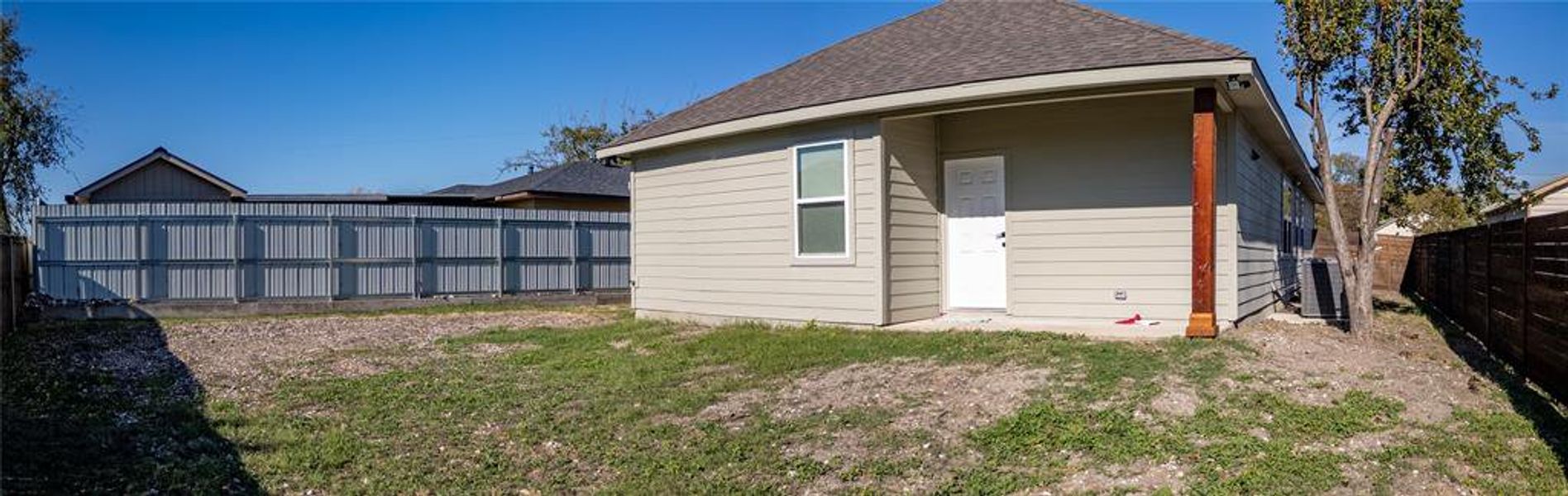 Back of property with a shingled roof and a fenced backyard