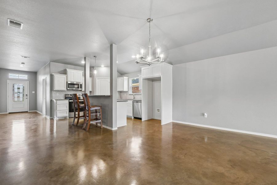 An open-concept living space integrates a well-appointed kitchen with sleek appliances and practical breakfast bar seating. An open-concept living space integrates a well-appointed kitchen with sleek appliances and practical breakfast bar seating.