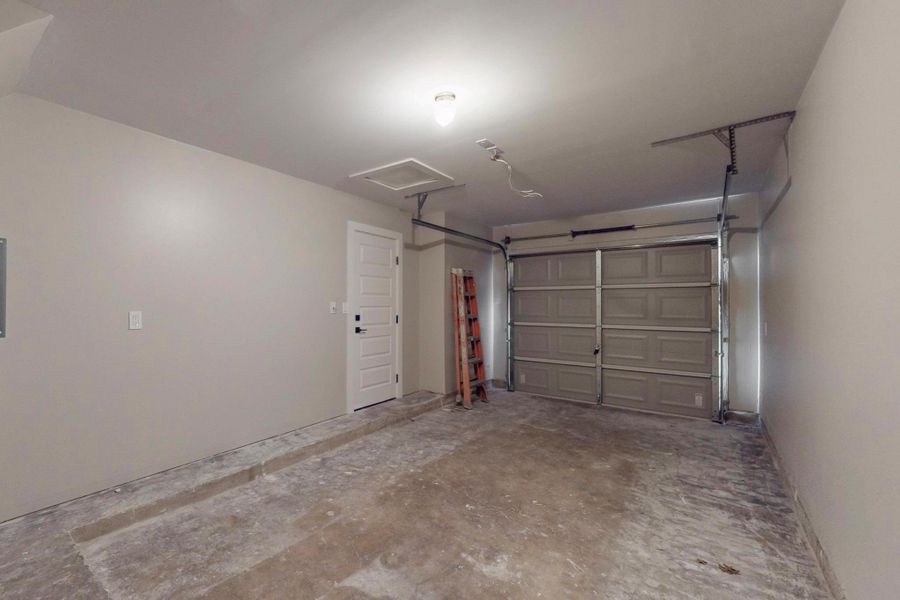 View of garage, with washer dryer connections in rear. These walls have been insulated, and the ceiling too.