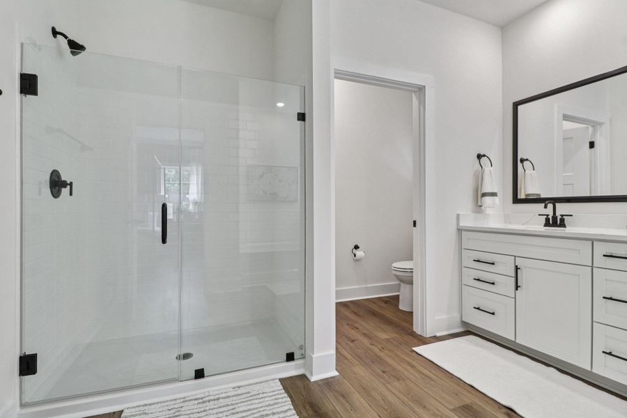 Full bath featuring vanity, a shower stall, and light wood-style flooring