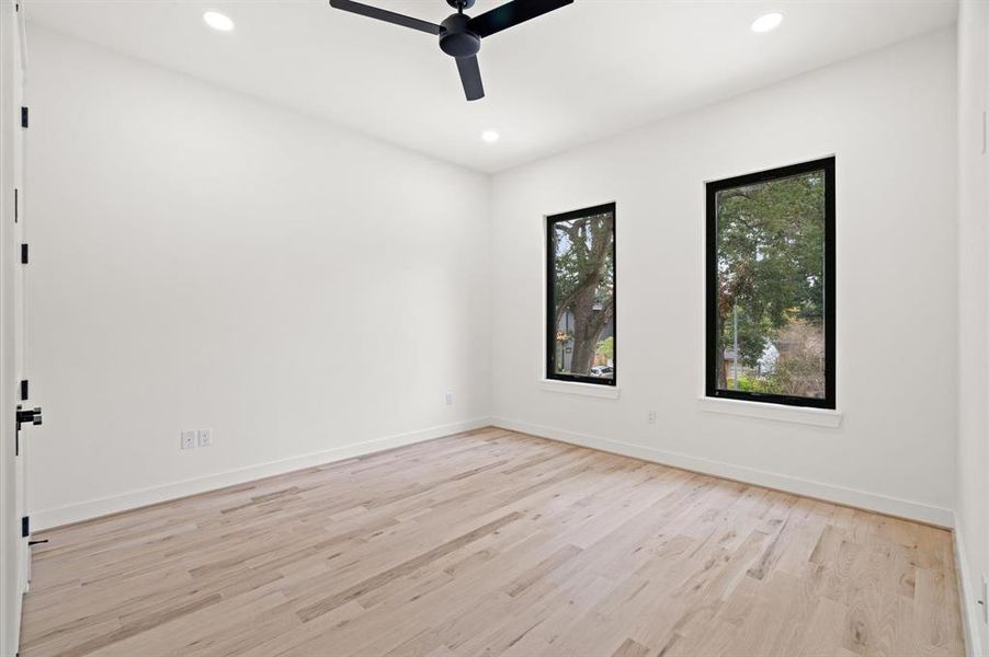 Secondary bedroom, each with recessed LED lighting, fan, and oak floors.