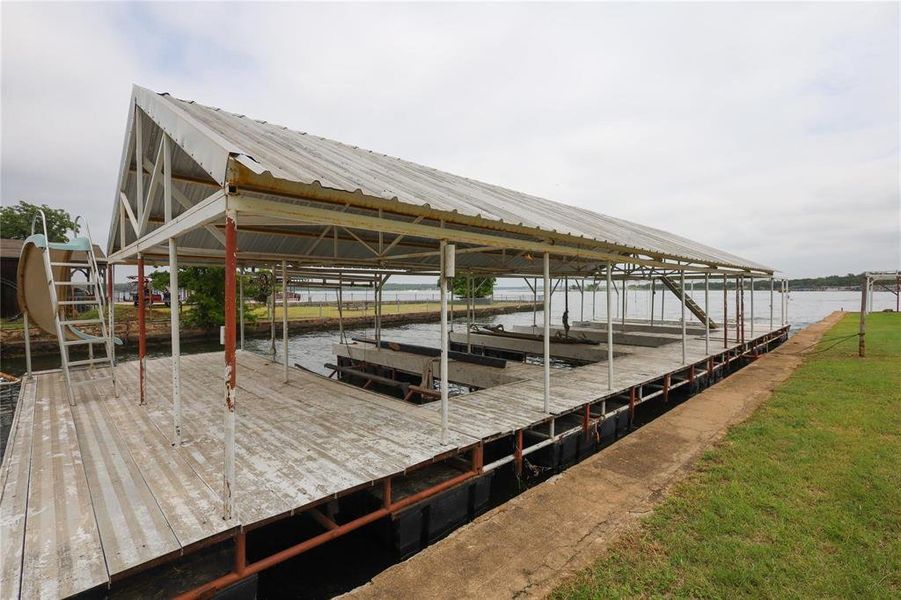 Dock featuring boat lift and a water view Dock featuring boat lift and a water view