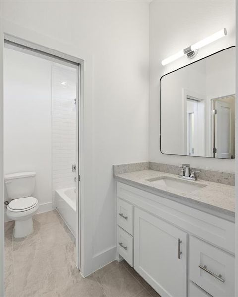 Full bathroom with tiled shower / bath, vanity, and toilet