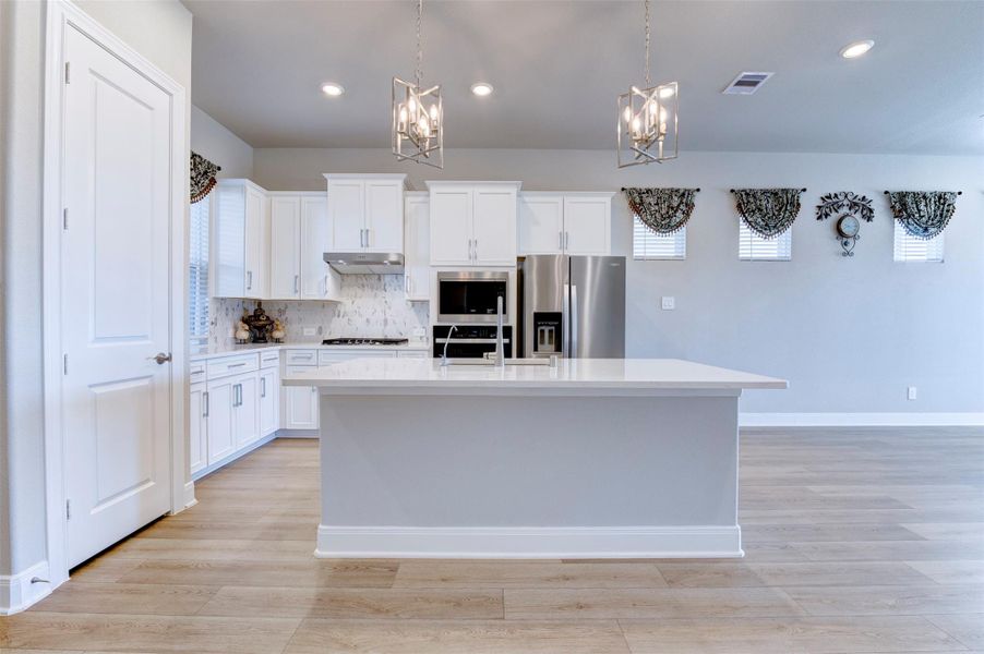 Bright kitchen with oversized island, modern cabinetry, and open-concept design.