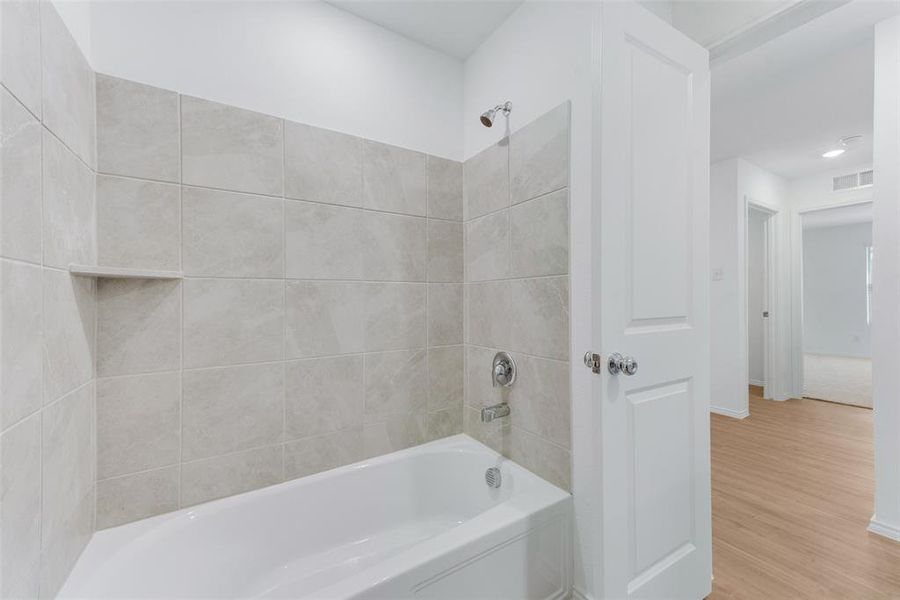 Bathroom featuring wood-type flooring and tiled shower / bath combo