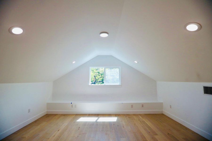 Bonus room with light wood-style flooring and recessed lighting