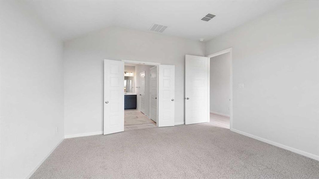 Unfurnished bedroom with lofted ceiling and light carpet