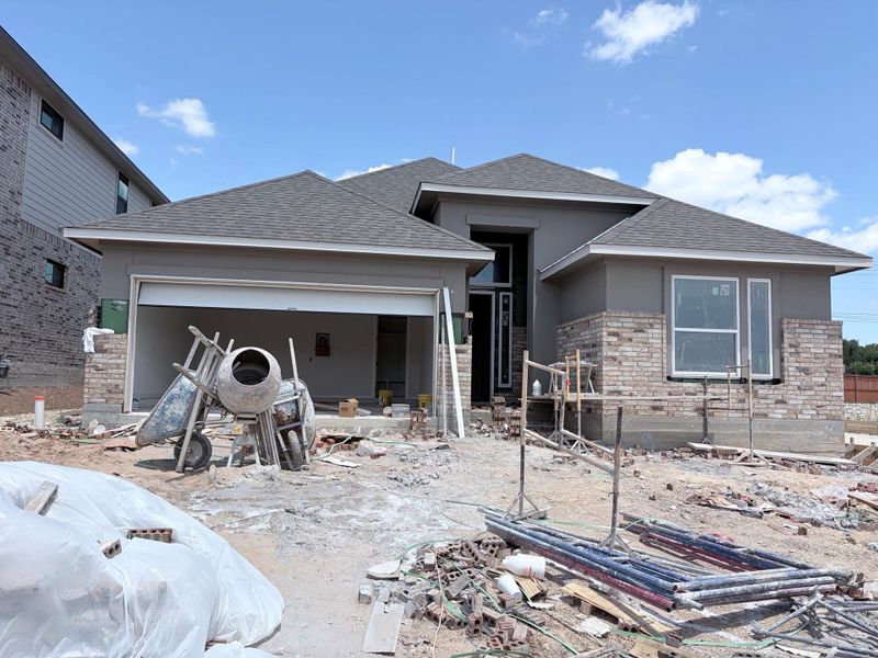 Under-construction residence showcases an integrated garage and brick and stucco facade, poised for completion. Under-construction residence showcases an integrated garage and brick and stucco facade, poised for completion.
