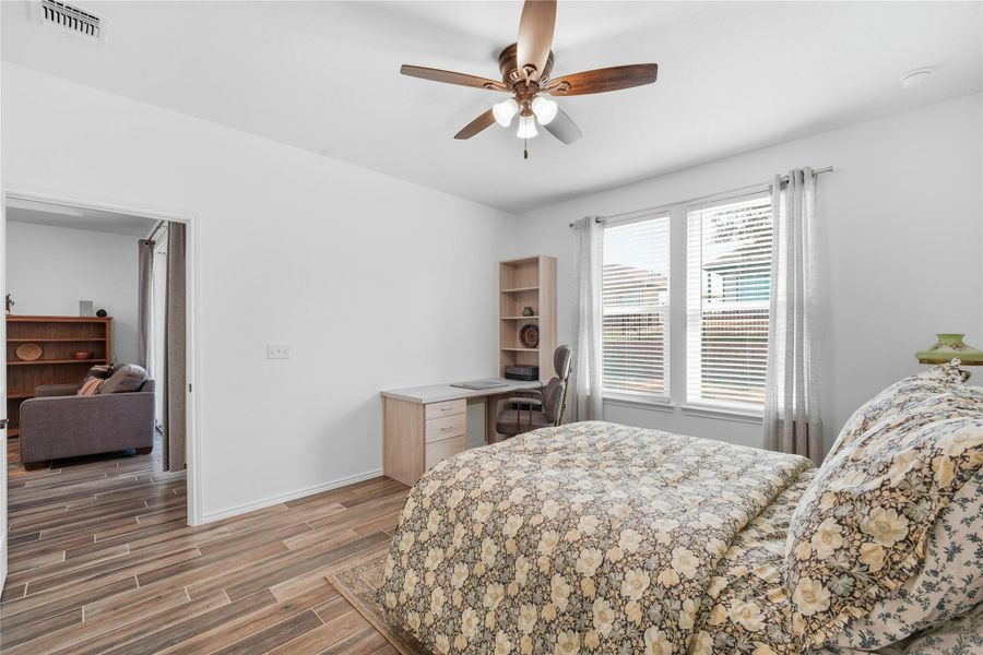Bedroom with wood tiled floors and a ceiling fan