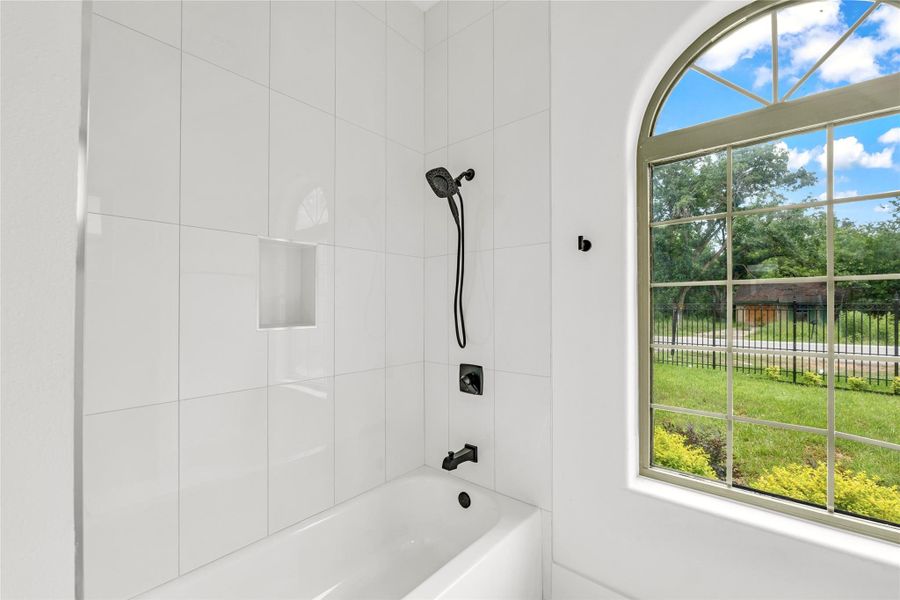 Bathroom 4 showcases arched windows and a tub/shower combo with handheld shower Bathroom 4 showcases arched windows and a tub/shower combo with handheld shower