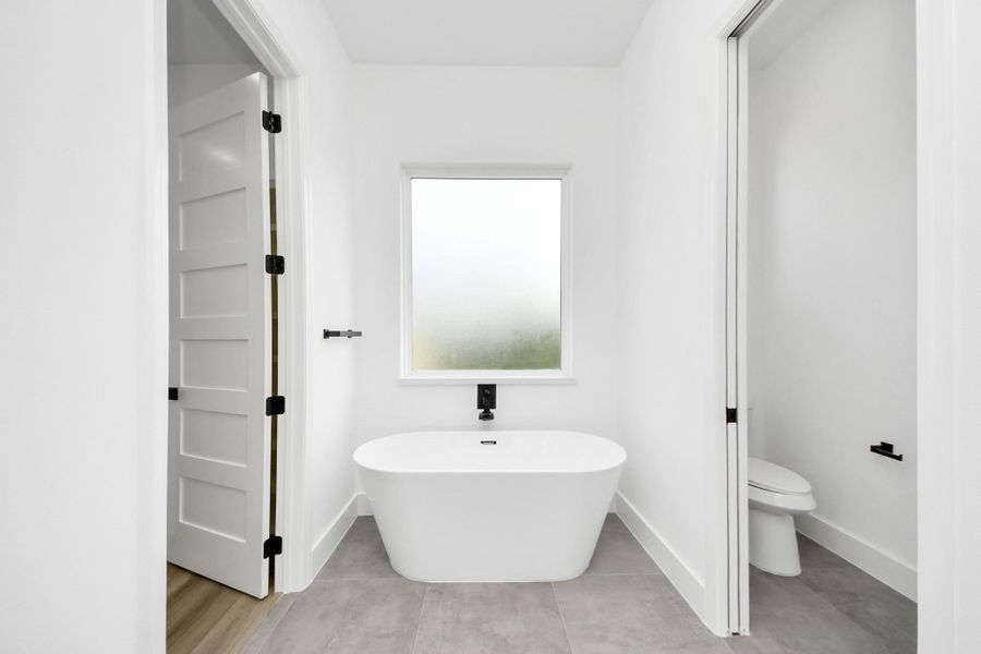 Primary bathroom w/ large soak in tub, frosted window for natural light. Primary bathroom w/ large soak in tub, frosted window for natural light.