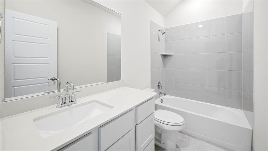 Bathroom with vanity, shower / tub combination, and lofted ceiling