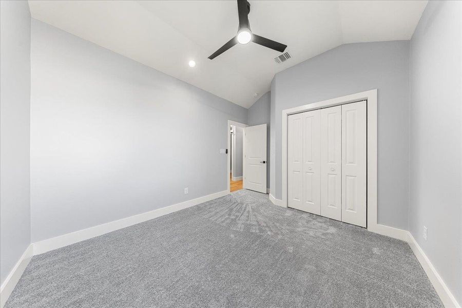 Unfurnished bedroom featuring lofted ceiling, carpet, a closet, a ceiling fan, and recessed lighting Unfurnished bedroom featuring lofted ceiling, carpet, a closet, a ceiling fan, and recessed lighting