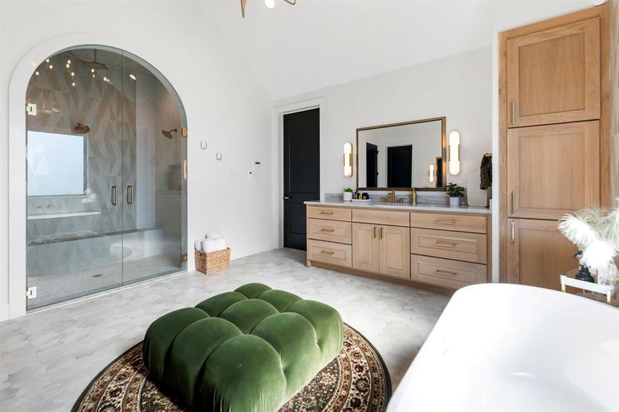 Bedroom featuring vaulted ceiling, ensuite bathroom, and light floors Bedroom featuring vaulted ceiling, ensuite bathroom, and light floors