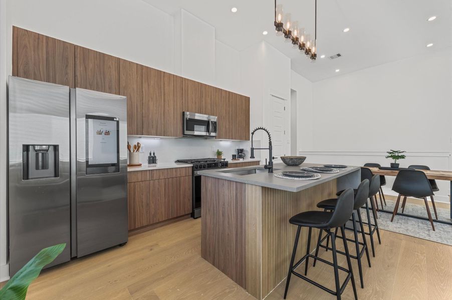 The heart of the second-floor open-concept living, dining, and kitchen, this spacious kitchen island features sleek modern finishes, including a one-sided cascade quartz countertop, a farmhouse sink, and stylish pendant lighting, with a built-in seating area perfect for casual breakfasts or chatting with family and friends.