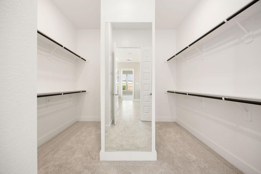 The spacious primary walk-in closet offers dual hanging rod systems on both sides, providing generous storage space. The spacious primary walk-in closet offers dual hanging rod systems on both sides, providing generous storage space.