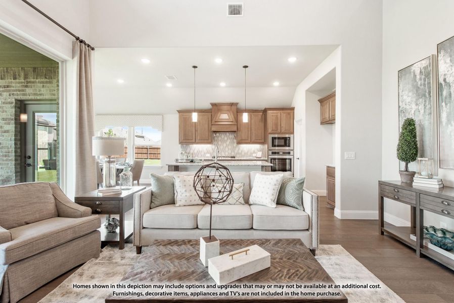 Open-concept living room with hardwood floors flowing into kitchen with wood cabinets and island Open-concept living room with hardwood floors flowing into kitchen with wood cabinets and island