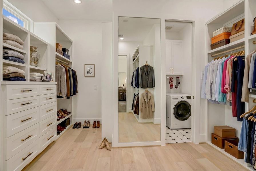 The primary closet includes ample storage space, full-length mirror and direct access to the utility room. Virtually staged photo. The primary closet includes ample storage space, full-length mirror and direct access to the utility room. Virtually staged photo.