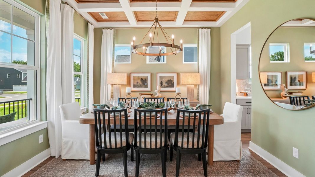 Dedicated dining area with coffered ceiling, natural lighting from windows, and access to kitchen Dedicated dining area with coffered ceiling, natural lighting from windows, and access to kitchen