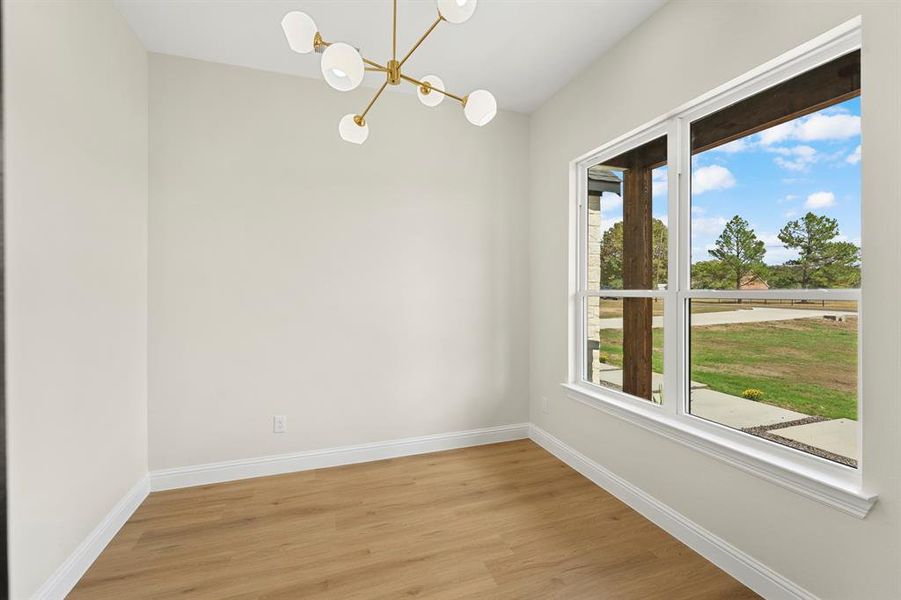 Unfurnished dining area featuring light wood-style flooring and a chandelier