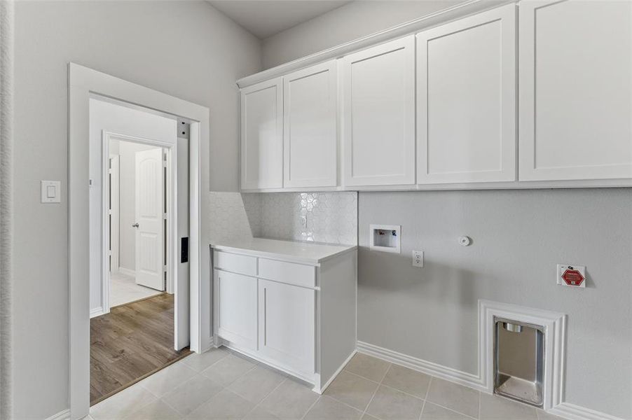 The property features an interior space with light gray walls, white cabinetry, and light-colored tile flooring