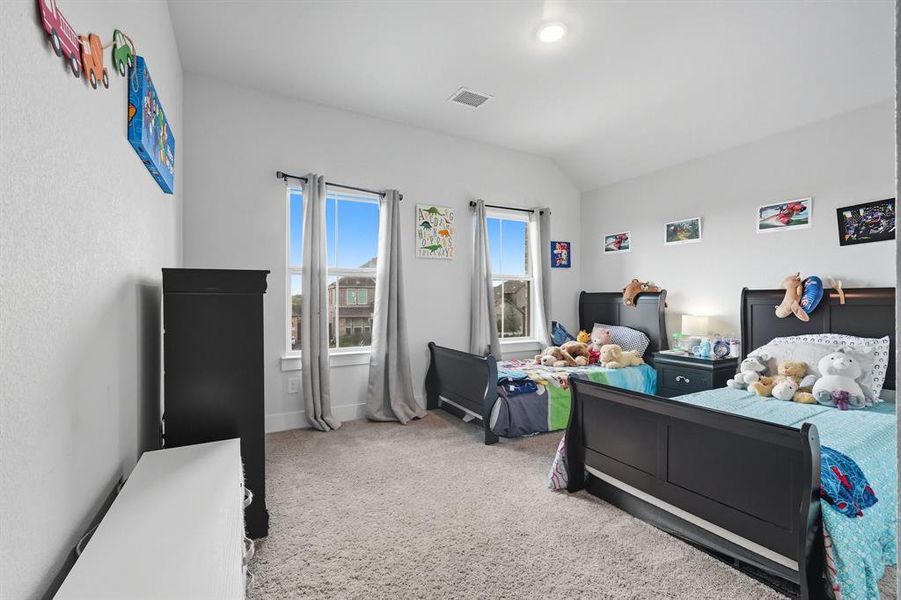 Bedroom featuring light carpet and lofted ceiling Bedroom featuring light carpet and lofted ceiling