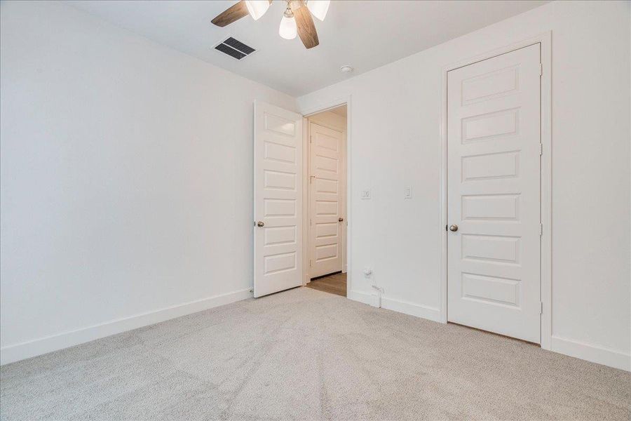This room features light-colored carpet, white walls, and white paneled doors