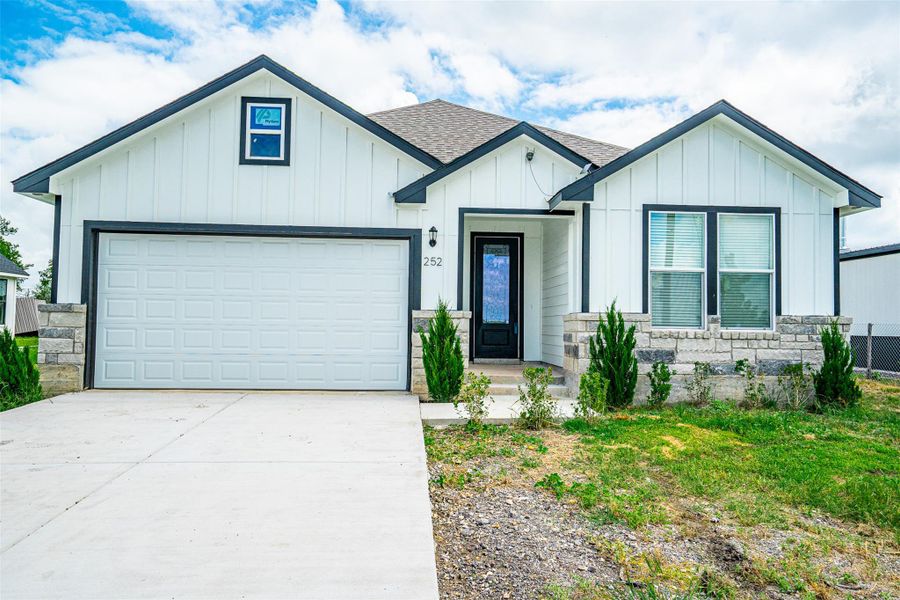 A modern facade with board and batten siding welcomes you home, boasting a two-car garage and inviting entry. A modern facade with board and batten siding welcomes you home, boasting a two-car garage and inviting entry.
