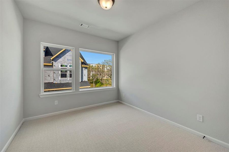 Empty room with light carpet and baseboards Empty room with light carpet and baseboards