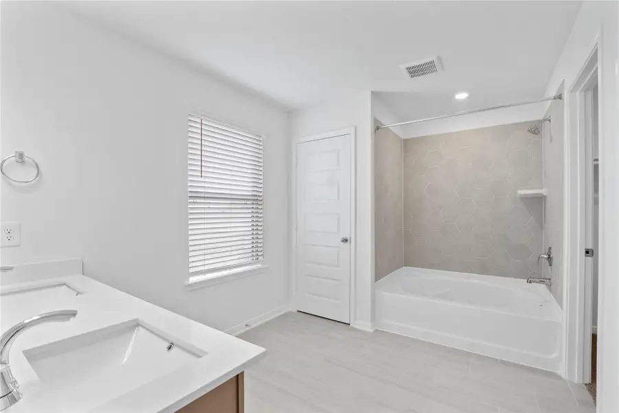 This additional view of the primary bath highlights the linen closet, oversized tub and shower combination with tile surround. This additional view of the primary bath highlights the linen closet, oversized tub and shower combination with tile surround.
