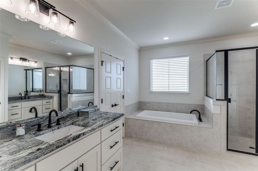 Bathroom with a shower stall, a garden tub, tile patterned flooring, vanity, and ornamental molding