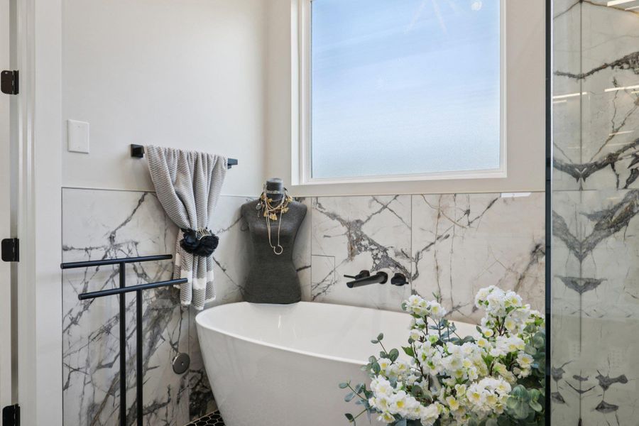 Full bath featuring a freestanding bath and tile walls