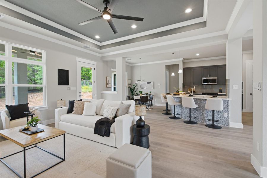 An inviting open-concept living space integrates a stylish kitchen with tray ceilings overhead. An inviting open-concept living space integrates a stylish kitchen with tray ceilings overhead.