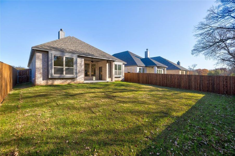 Rear view of house with a lawn and ceiling fan