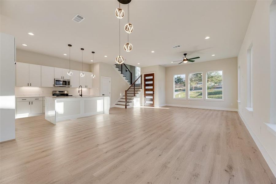 Unfurnished living room featuring light wood-style floors, stairway, recessed lighting, and ceiling fan Unfurnished living room featuring light wood-style floors, stairway, recessed lighting, and ceiling fan
