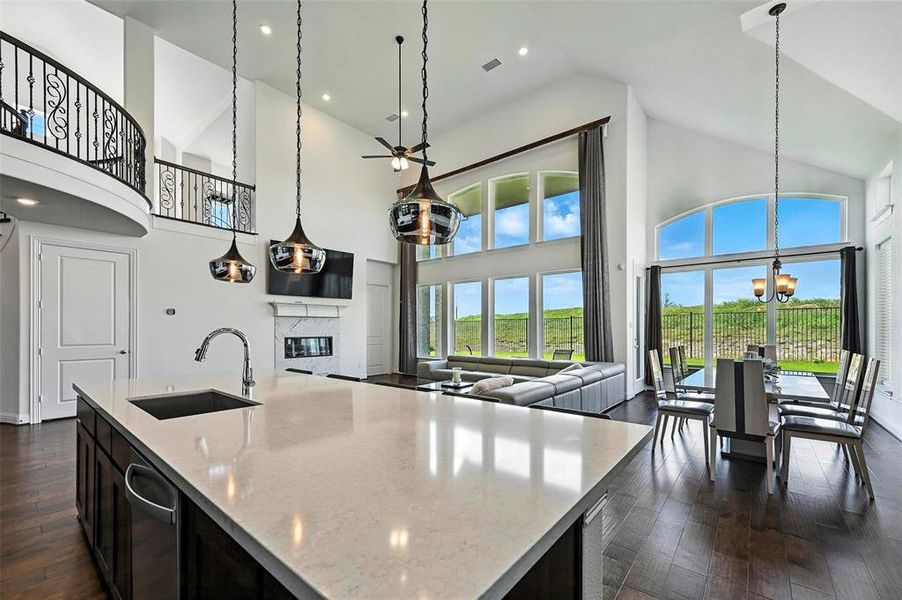 Kitchen with high vaulted ceiling, open floor plan, a fireplace, dark wood-style floors, and a chandelier