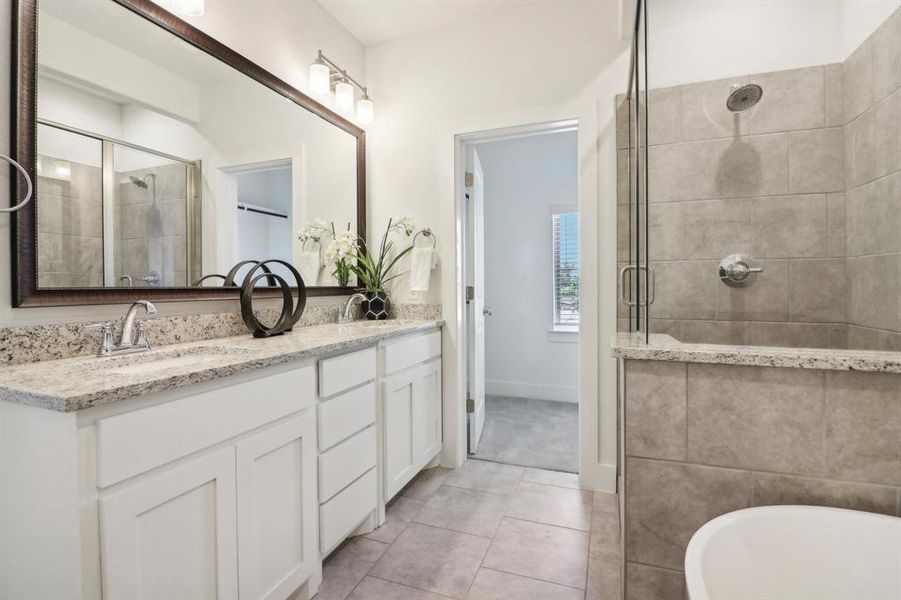 Bathroom with tile patterned flooring, vanity, and plus walk in shower