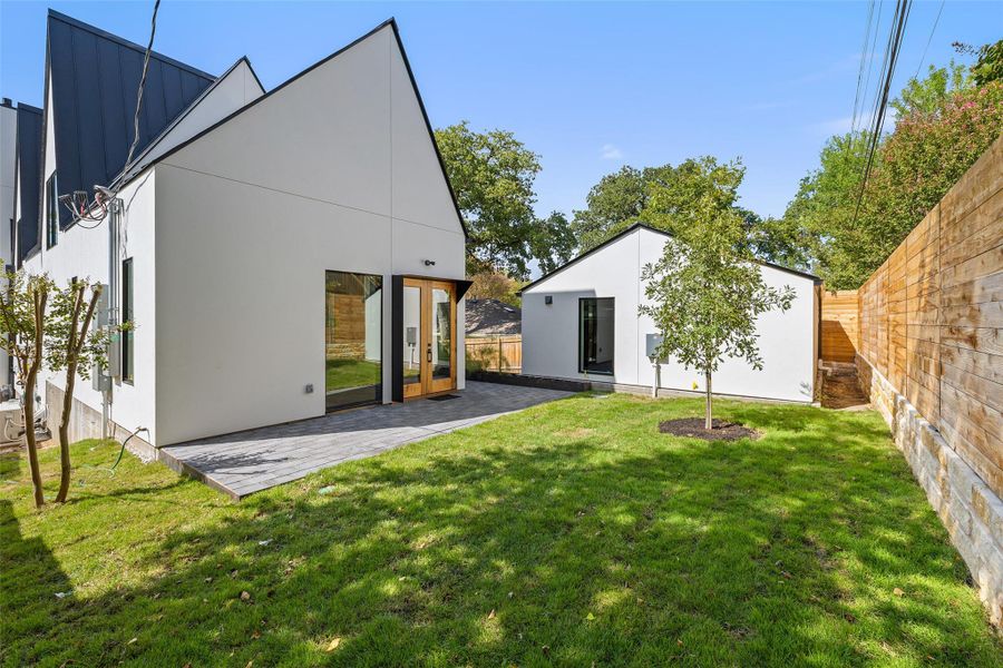Rear view of property with french doors, stucco siding, a patio, and an outbuilding